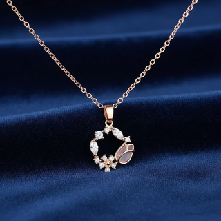 Rose gold necklace with a circular pendant on a blue fabric background