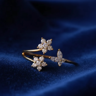 Gold ring with diamond flowers on a blue fabric background