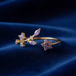 Gold ring with purple gemstones on a dark blue fabric background