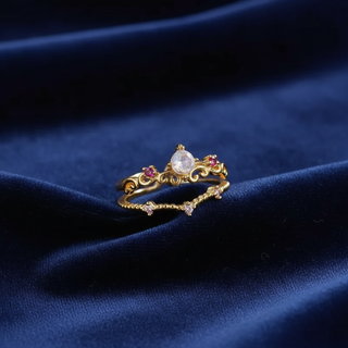 Gold ring with gemstones on a blue fabric background