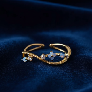 Gold bracelet with gemstones on a dark blue fabric background