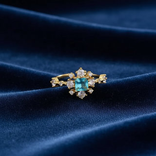 Gold ring with a blue gemstone on a dark blue fabric background