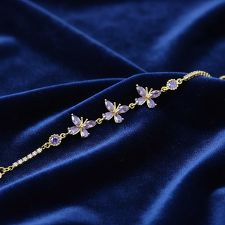 Gold bracelet with purple gemstones on a blue velvet background